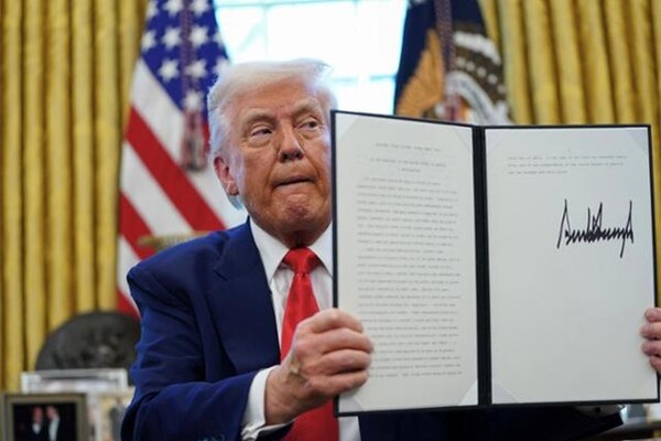 President Donald Trump holds up a document after signing an executive order at the White House in Washington on April 9. (Photo source: Reuters)