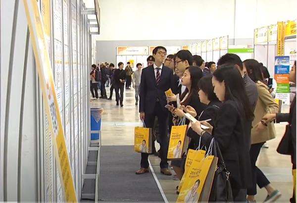 Jobseekers look at job postings at a job fair in Seoul. (Captured from YTN)