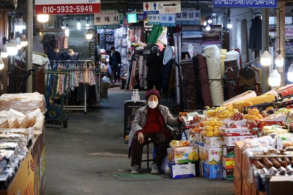 A shopkeeper naps as she waits for customers at a traditional market in Seoul. REUTERS