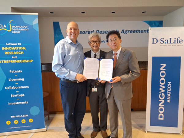 Kim Dong-cheol (right), CEO of Dongwoon Anatech, poses for a commemorative photo with Amir Naiberg (left), vice chancellor, and Dr. David Wong at the University of California, Los Angeles (UCLA) on July 18 (local time) after signing a joint research agreement. (Photo courtesy of Dongwoon Anatech)