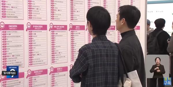 Jobseekers look at job postings posted at a job fair in Seoul. (Captured from KBS)